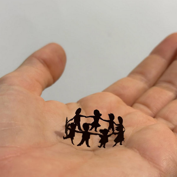 miniature paper cutting of children in circle holding hands